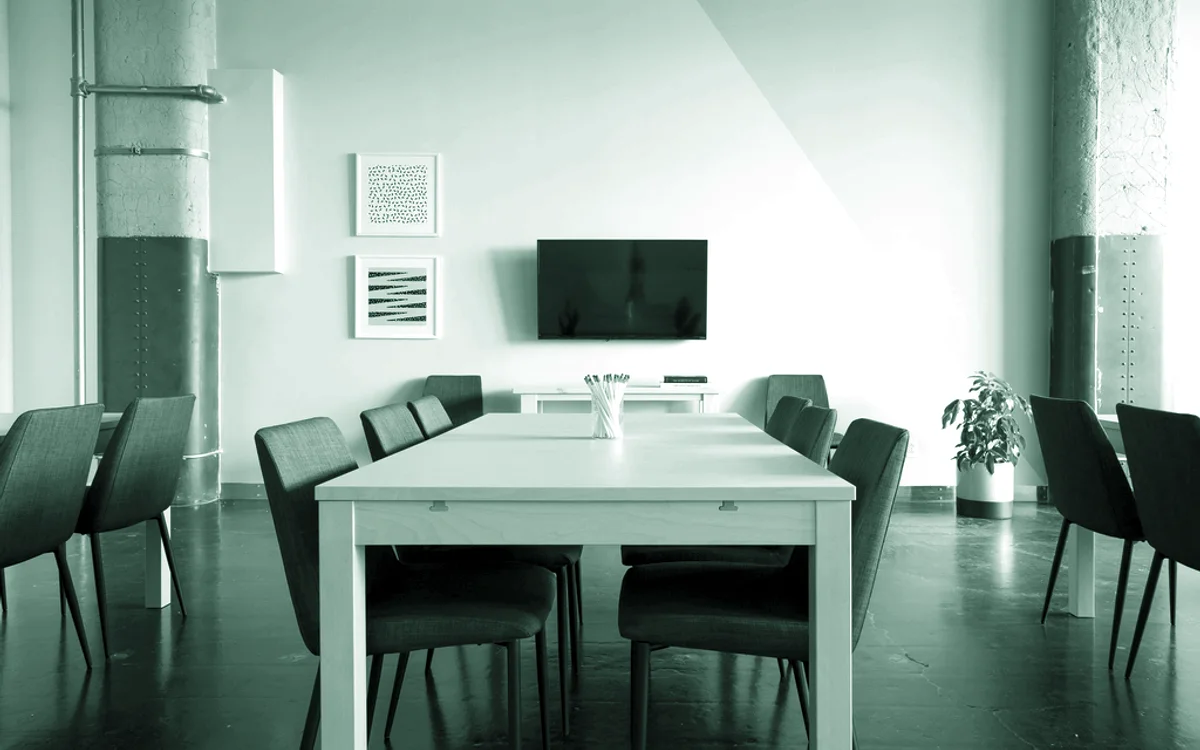 Una sala de reuniones vacía con la mesa y las sillas dispuestas